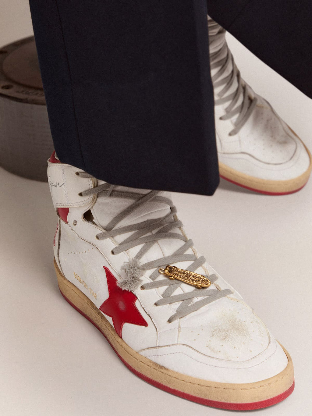 Men's lace accessory in old gold color in the shape of a skateboard