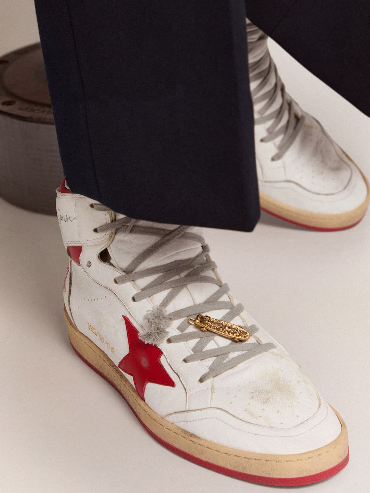 Men's lace accessory in old gold color in the shape of a skateboard