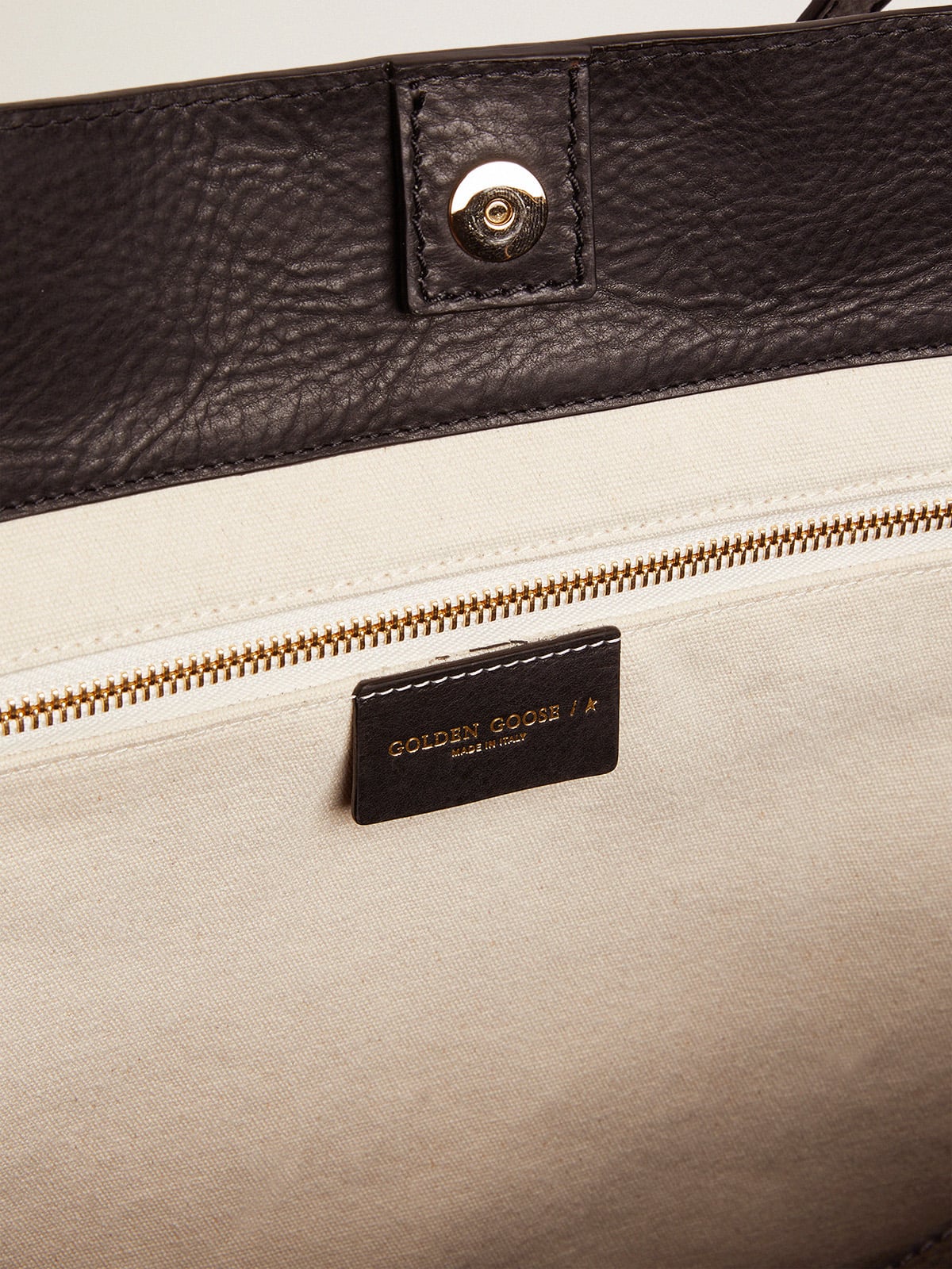 Pasadena Bag in black hammered leather with gold logo on the front