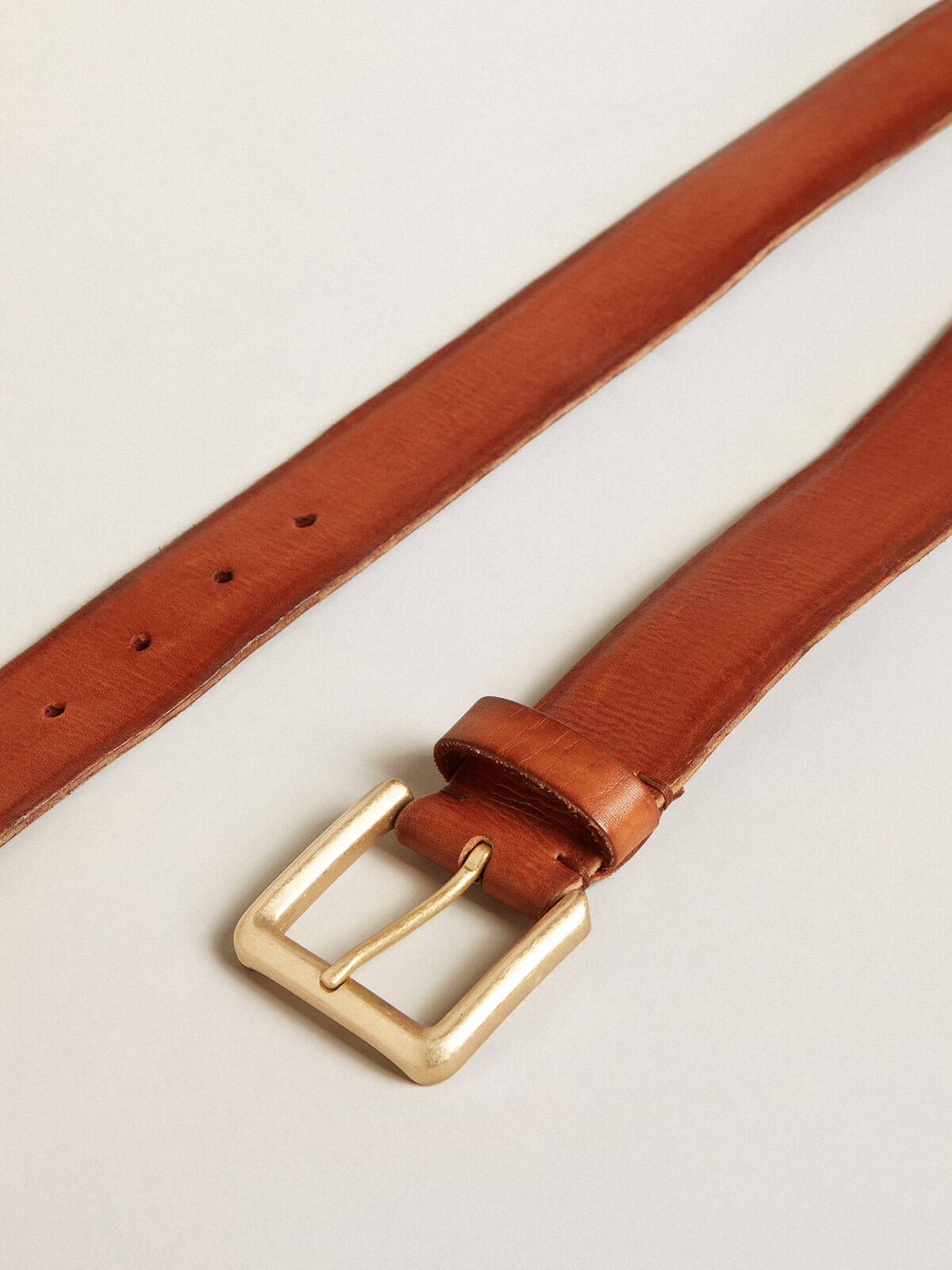 Belt in tan-colored washed leather with raised print