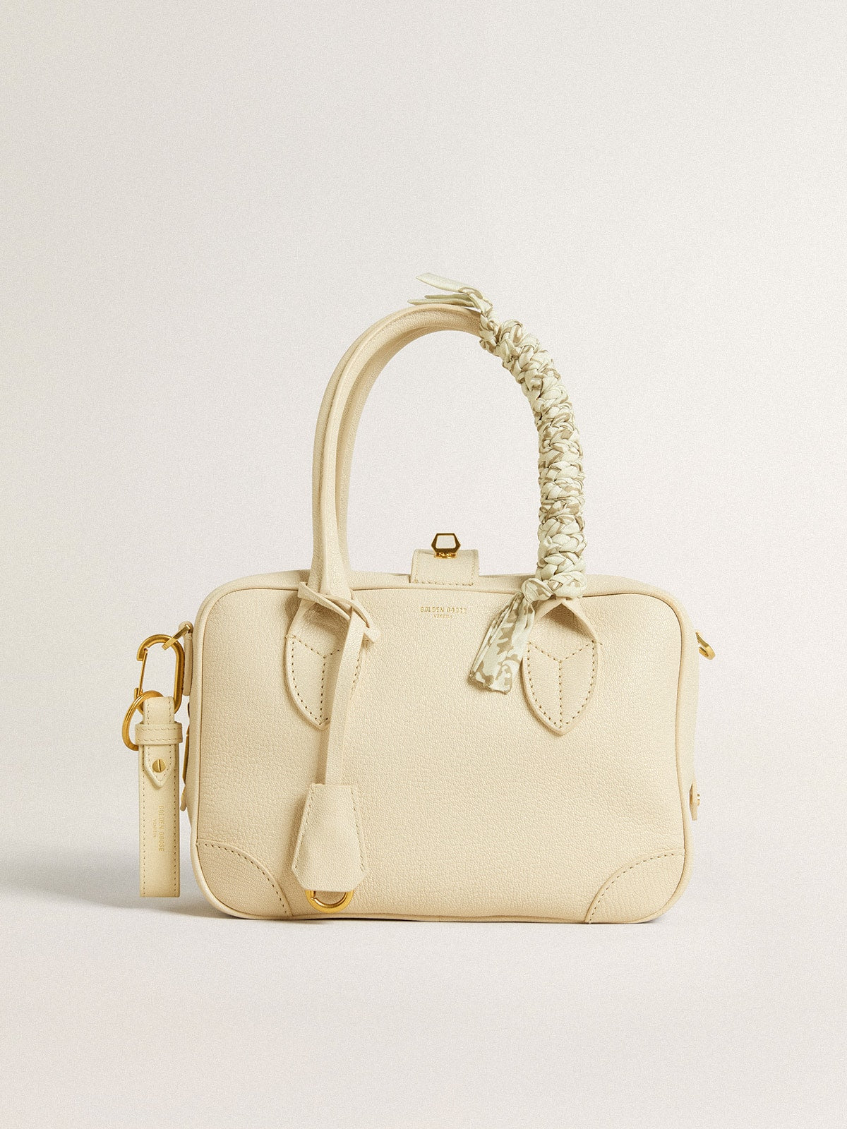 Butter-colored braided fabric charm with brass chain