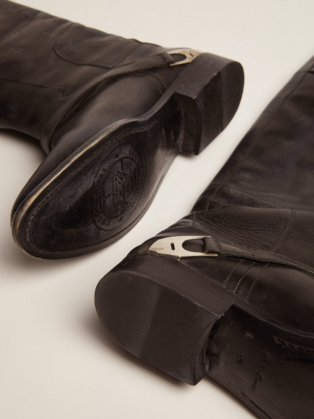 Women's black leather boots with clamp on the heel
