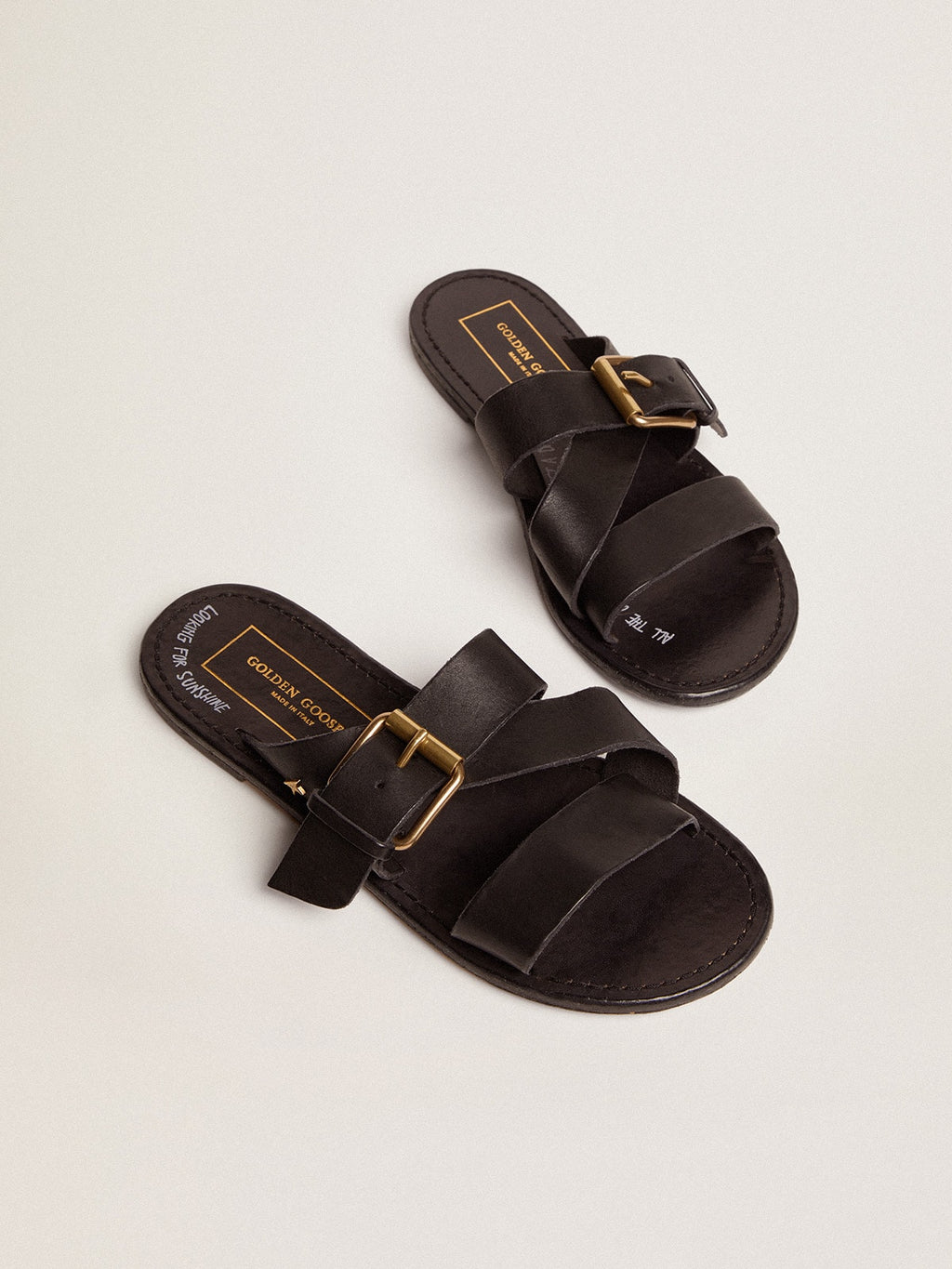 Margaret flat sandals in black resin-coated leather