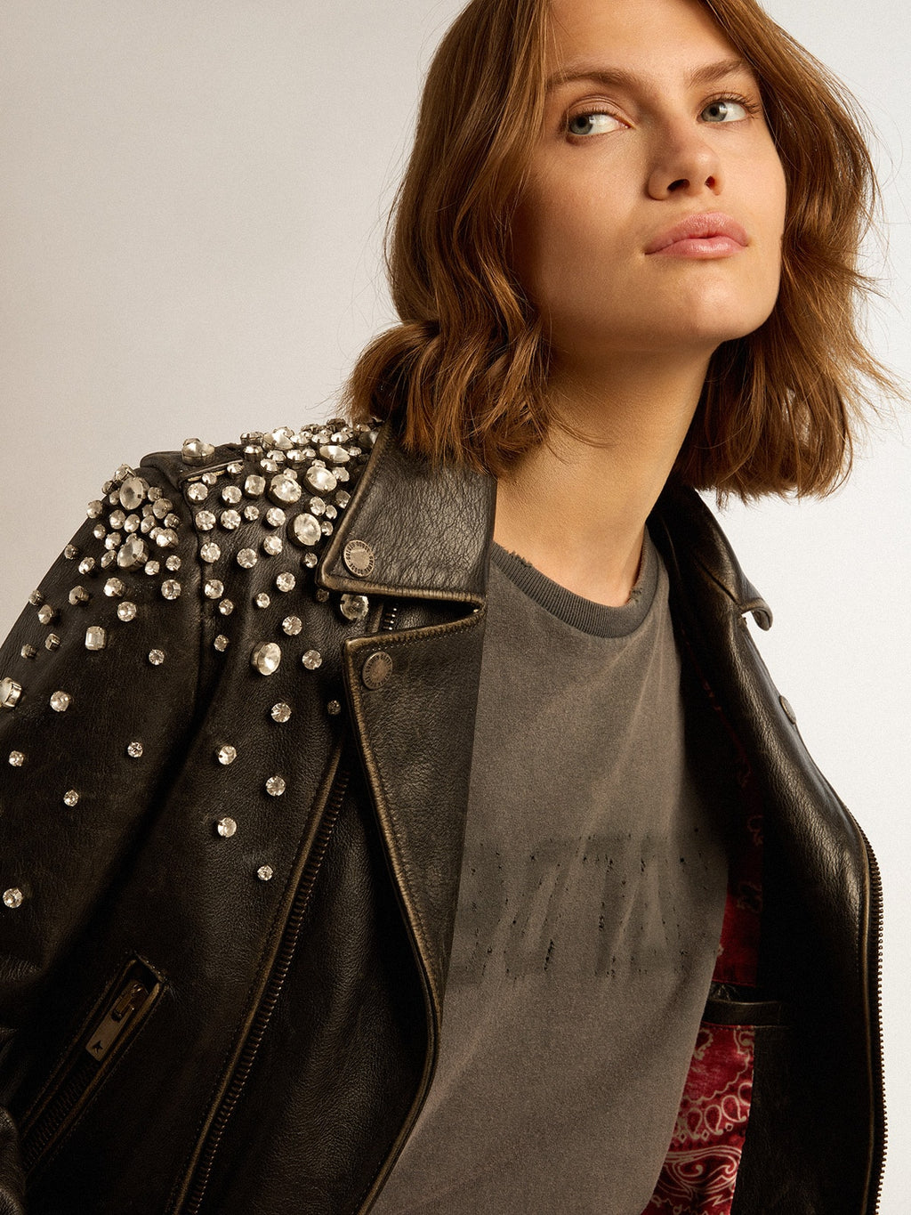 Women's biker jacket in distressed leather with cabochon crystals