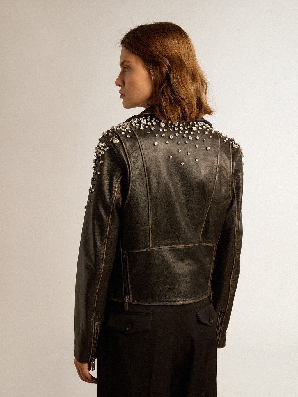 Women's biker jacket in distressed leather with cabochon crystals
