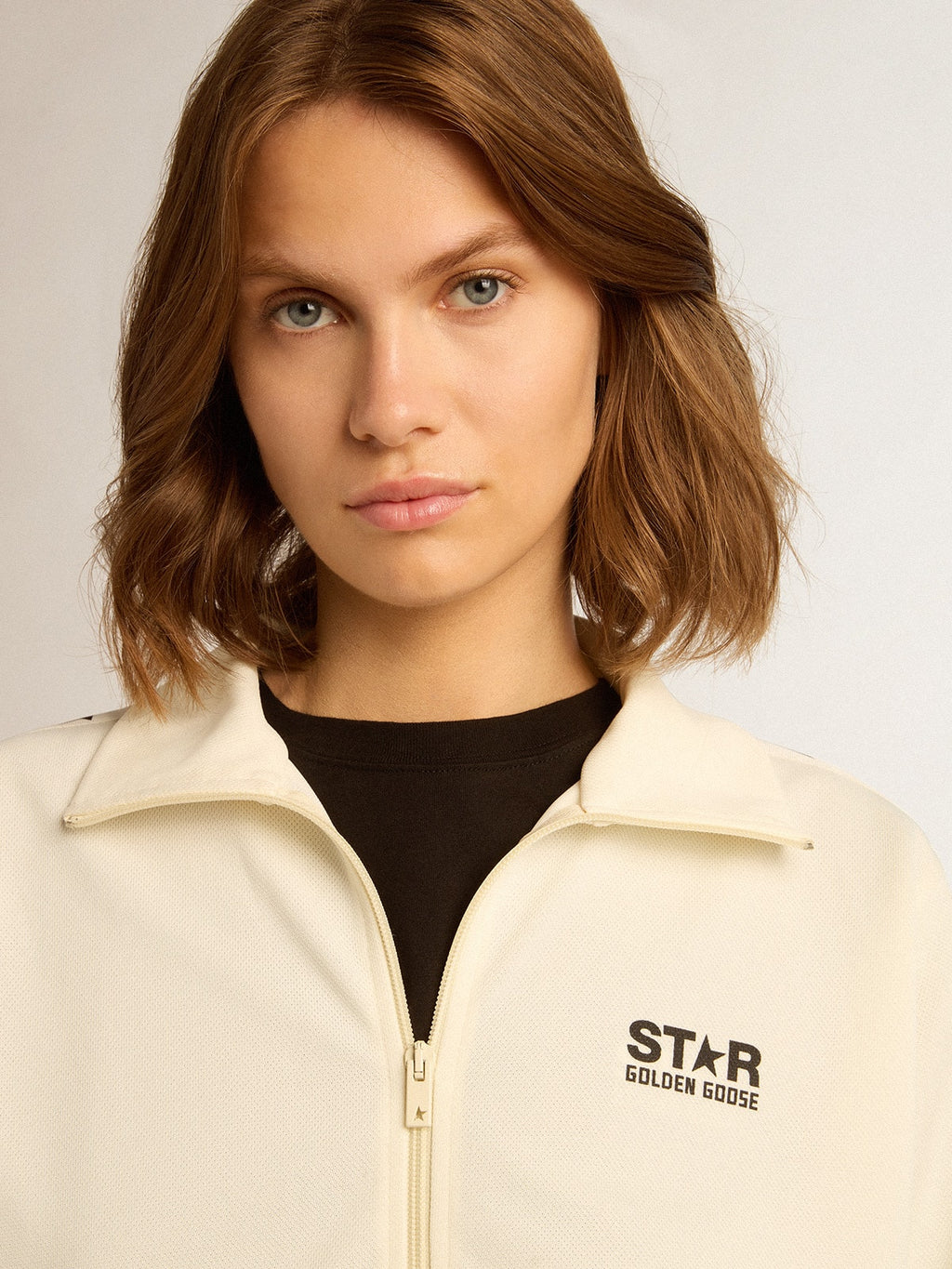 Women’s white zipped sweatshirt with white strip and black stars