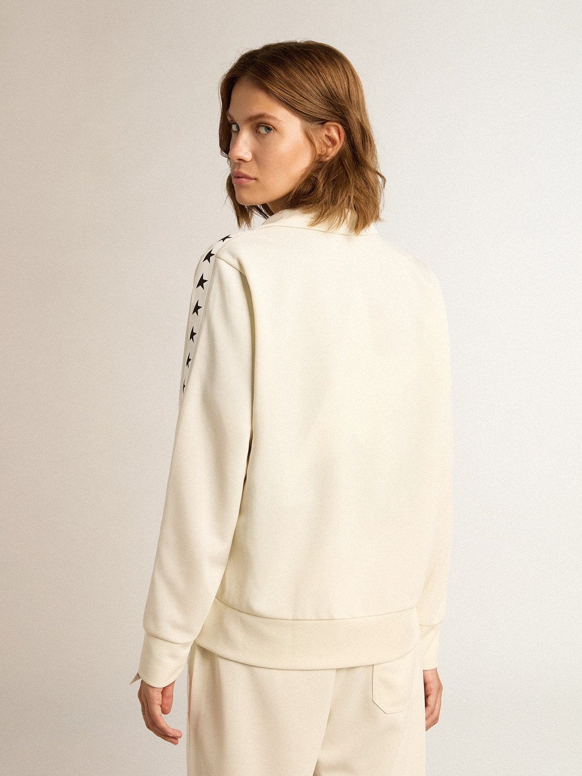 Women’s white zipped sweatshirt with white strip and black stars